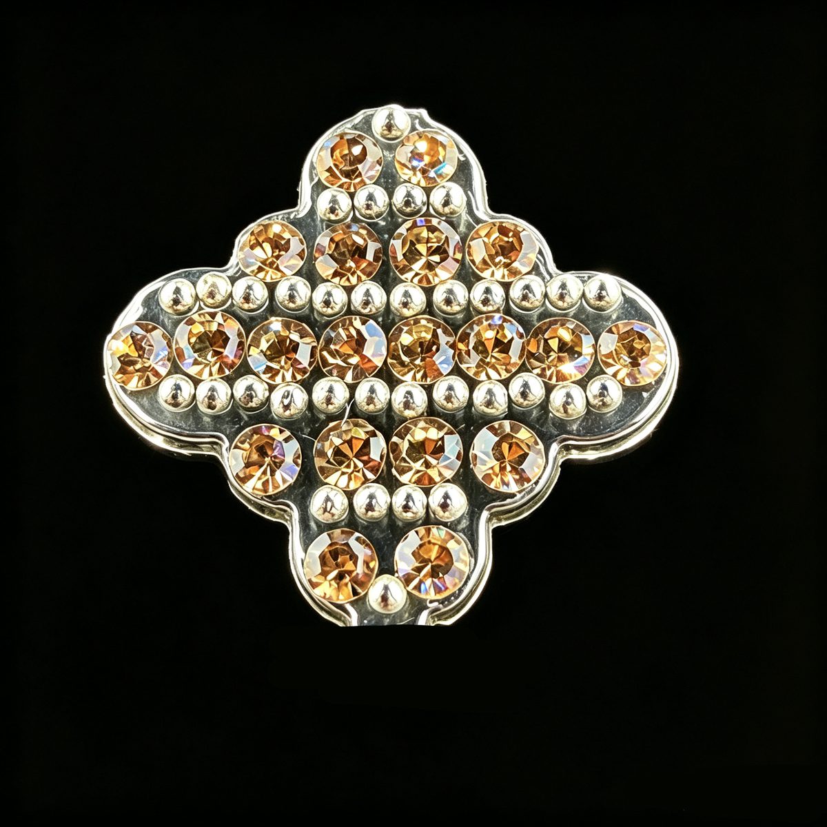 Close view of metal balls and faceted rhinestones in rows on a quatrefoil sticker